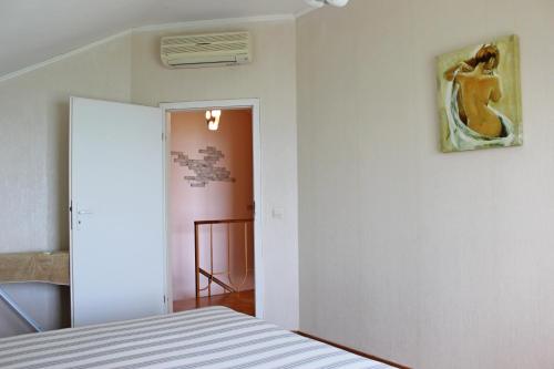 1 dormitorio con 1 cama y una pintura en la pared en Sovinyon, en Odessa
