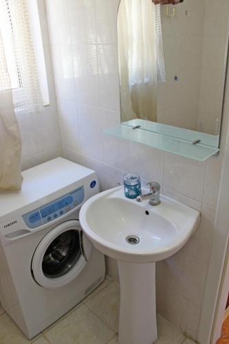 a bathroom with a washing machine and a sink at Sovinyon in Odesa