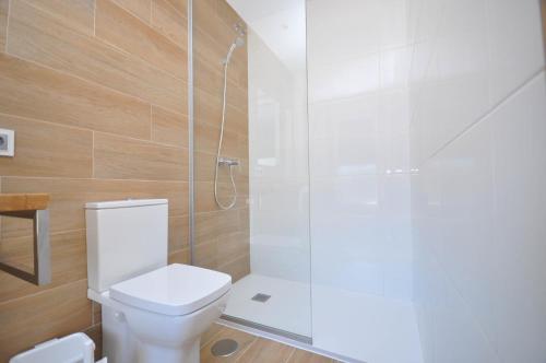 a bathroom with a toilet and a glass shower at Casa Chelo Alojamientos Turisticos in Mazaricos