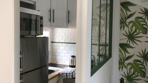a kitchen with white cabinets and green plants on the wall at Saint-Tropez walking distance, sea view house in Saint-Tropez