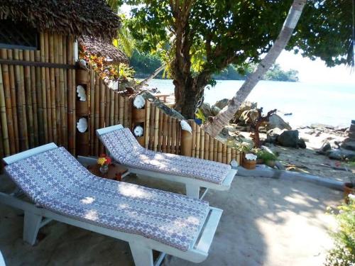 a couple of chairs sitting next to a fence at Remo e Berenice in Nosy Komba