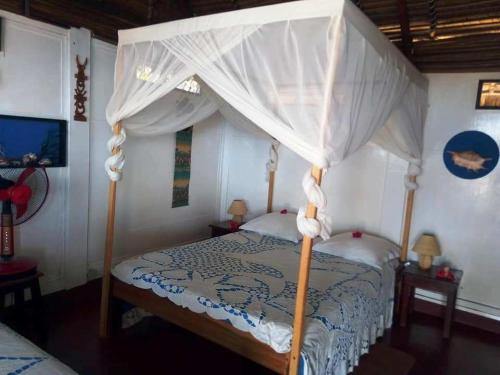 a bedroom with a bed with a canopy at Remo e Berenice in Nosy Komba