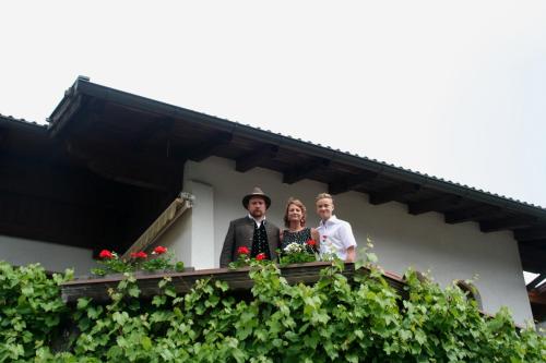 three people standing on a balcony of a house at Ferienwohnung Pupeter in Arzl im Pitztal