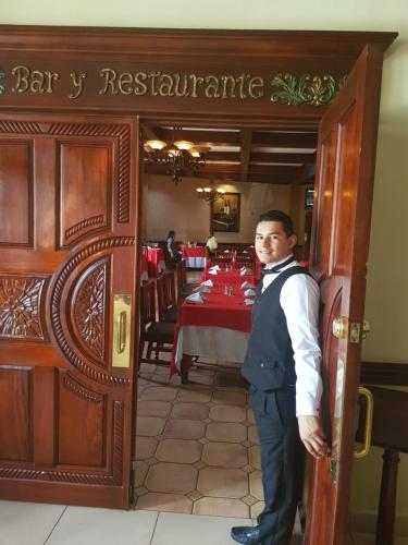 a man standing in the doorway of a restaurant at Hotel Florencia in San Miguel