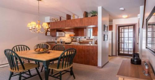 a kitchen and dining room with a table and chairs at Aiglon by Rendez-Vous Mont-Tremblant in Mont-Tremblant