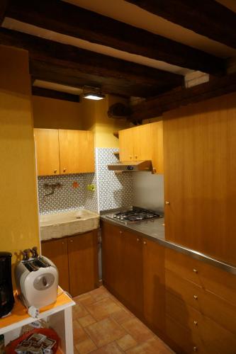 uma cozinha com armários de madeira e um forno com placa de fogão em Casa delle gondole em Veneza