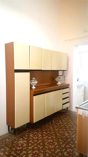 a kitchen with a counter with white cabinets at Dai nonni in Niscemi