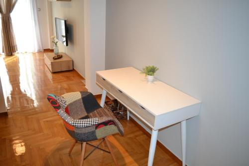 a white desk and a chair in a room at Leon Cozy Apartment in Athens