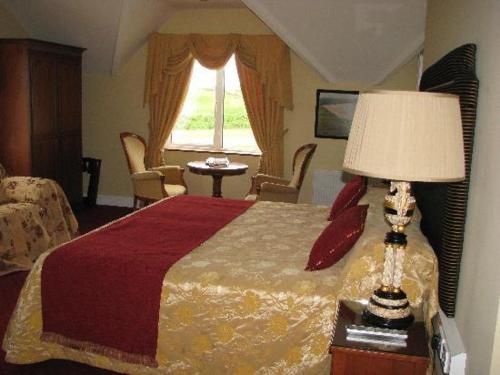 a bedroom with a bed with a lamp and a window at The 19th Golf Lodge in Ballybunion