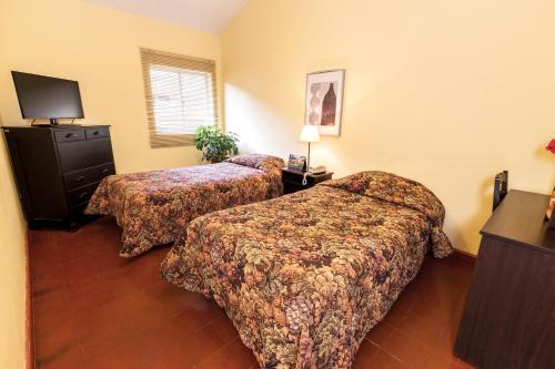 a hotel room with two beds and a television at LP Express Hotel Tarma in Tarma