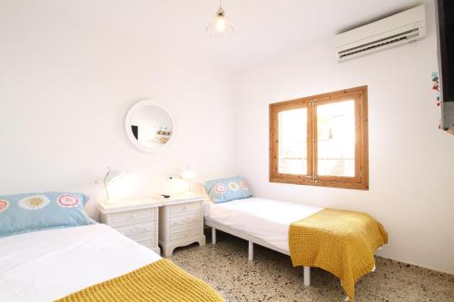 1 Schlafzimmer mit 2 Betten und einem Fenster in der Unterkunft Pollenca Townhouse in Pollença