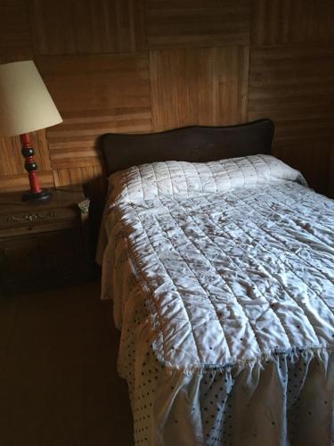 a bed with a white comforter in a bedroom at Posada Santa María in Mineral del Chico