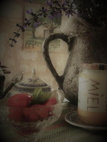 a table with a bowl of fruit and a vase at Bastida de Beata in Noailles