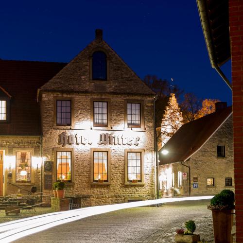 an old stone building with writing on it at night at Hotel Winter in Schöppingen