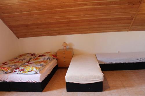 two beds in a room with wooden ceilings at Vinařství Bičian in Vrbovec