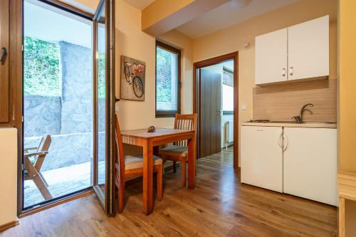 a kitchen and dining room with a table at Guest house Boračko Lake in Jezero