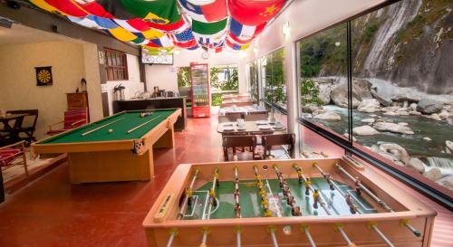 a room with a pool table and a waterfall at Casa Machu Picchu Hostel in Machu Picchu