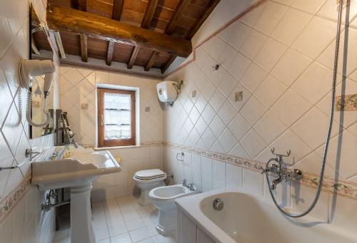 łazienka z umywalką, toaletą i wanną w obiekcie Borgo Terrosi w mieście Sinalunga