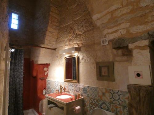 baño con lavabo y pared de piedra en Bastida de Beata, en Noailles