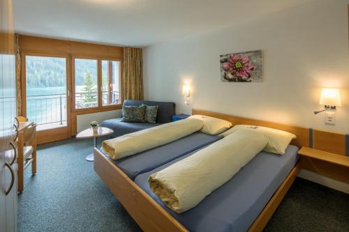 a bedroom with a large bed and a window at Hotel Seebüel in Davos