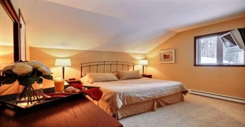 a bedroom with a large bed and a window at Aiglon by Rendez-Vous Mont-Tremblant in Mont-Tremblant