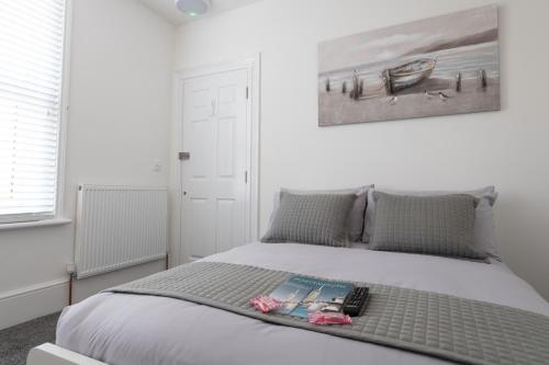 a bedroom with a bed with a book on it at Southsea Studios - Luxury Seaside Apartments in Portsmouth