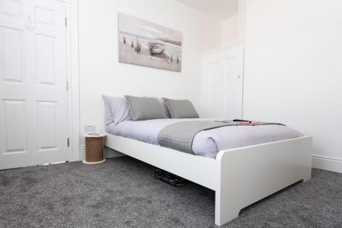 a white bed in a white room with at Southsea Studios - Luxury Seaside Apartments in Portsmouth