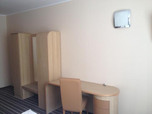 a room with a wooden desk and a chair at Hotel Julian in Szczecin
