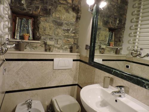 a bathroom with a sink and a toilet and a mirror at Il Giardino Segreto in Tellaro