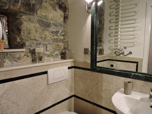 uma casa de banho com um lavatório, um WC e um espelho. em Il Giardino Segreto em Tellaro
