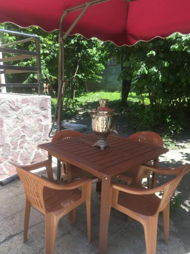 a wooden table and chairs under an umbrella at Fairy Tale in Gabala