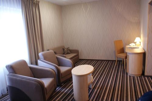 a hotel room with chairs and a table and a waiting room at Hotel Julian in Szczecin
