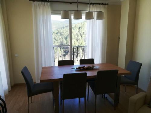 mesa de comedor con sillas y ventana grande en Vive Montanejos!, en Montanejos