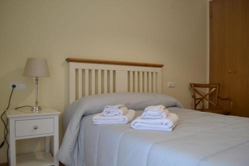1 dormitorio con 1 cama con toallas en Vive Montanejos!, en Montanejos