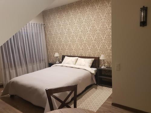 a bedroom with a large bed with white sheets at Rīteņi in Ķesterciems