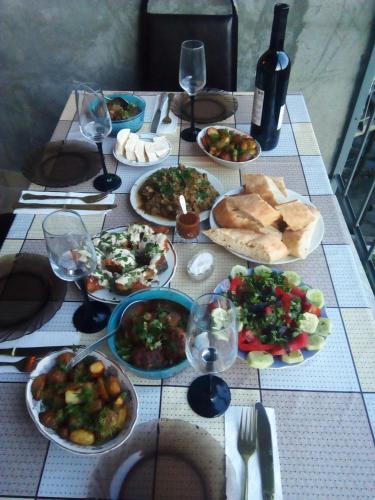 a table topped with plates of food and wine glasses at Best Host in Sighnaghi