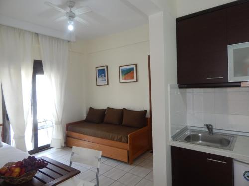 a kitchen with a couch and a sink in a room at Kripis Studio in Pefkohori