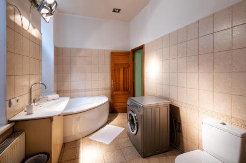 La salle de bains est pourvue d'un lavabo et d'un lave-linge. dans l'établissement Riga City Family Apartment, à Riga