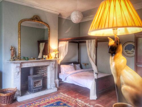 a bedroom with a bed and a lamp and a fireplace at 84 Saint Andrews Road in Bridport