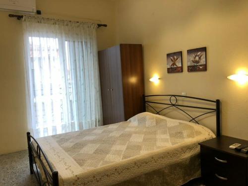 a bedroom with a large bed and a window at Anna Georgiou in Skala Sotiros