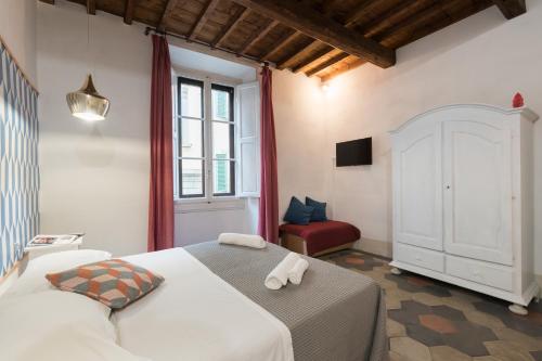 1 dormitorio con 1 cama blanca y 1 silla roja en F7 - Santa Croce one bedroom flat for 2 or 3 guests, en Florencia