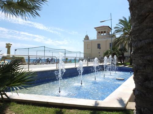 a pool with water fountains in front of a building at Casa Amico Mare in Loano