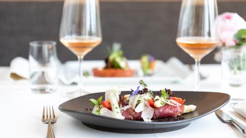a plate of food on a table with wine glasses at Ladurner in Lagundo
