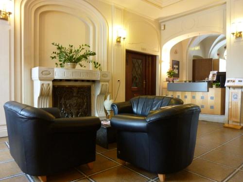 a lobby with two chairs and a fireplace at Hotel Schloss Schweinsburg in Neukirchen-Pleiße