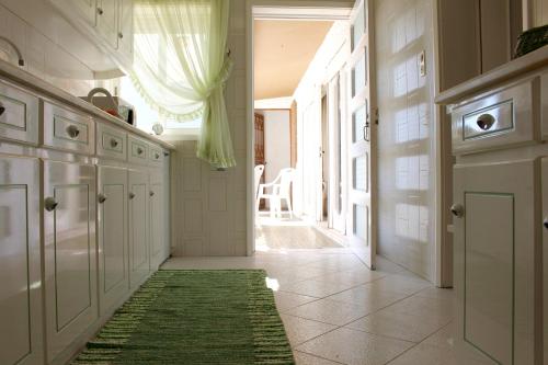 a hallway of a kitchen with a green rug at Cozy Summer House by the Beach in Ovar