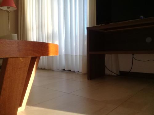 a living room with a television and a couch and a table at 11 Peyret Rent Aparts in Colón