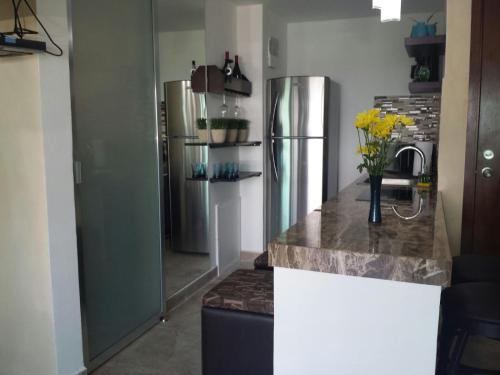 a kitchen with a refrigerator and a counter top at Cozy and Modern in Cancún