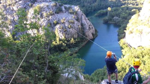 two people on a zip line over a river at Mini stone house in Omiš