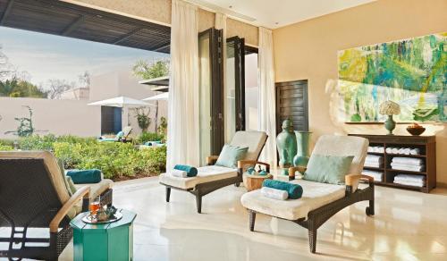 - un salon avec des chaises et une grande fenêtre dans l'établissement Four Seasons Resort Marrakech, à Marrakech