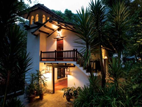 a house with a balcony on the side of it at Inkaterra Machu Picchu Pueblo Hotel in Machu Picchu